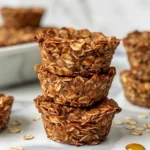 Baked protein oatmeal cups with various toppings, arranged on a wire rack.