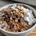 Close-up of a bowl of Rocky Road Protein Oatmeal, topped with marshmallows, chocolate chips, and pecans.