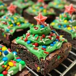 Close-up of Christmas Tree Brownie Bites with green frosting and holiday sprinkles.