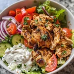 Close-up view of a delicious chicken shawarma bowl featuring chicken, rice, and fresh vegetables.