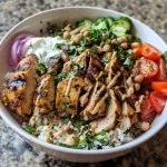 A close-up side view of a Chicken Shawarma Rice Bowl showcasing juicy chicken thighs over fluffy Basmati rice with colorful fresh toppings.