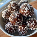 Close-up view of chocolate coconut energy balls with a shiny surface.