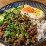 A close-up view of a Korean Ground Beef Bowl, showcasing juicy ground beef, colorful vegetables, and rice.