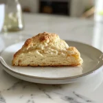 Close-up view of freshly baked scones on a wooden surface.