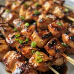 Juicy Teriyaki chicken skewers arranged beautifully on a plate.