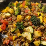 A close-up side view of a Vegetable Beef Skillet showcasing colorful veggies and ground beef.
