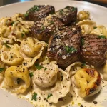Close-up of garlic steak tortellini in cream sauce, showcasing the texture and colors.