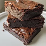 Close-up side view of a fudgy brownie, showcasing its rich, moist texture.