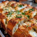 Close-up side view of cheesy garlic pull-apart bread with melted cheese oozing out.