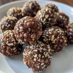 Close-up of chocolate almond balls covered in cocoa powder and adorned with flaked sea salt.
