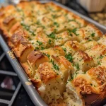Close-up view of a loaf of golden garlic and cheese pull-apart bread.