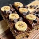 Close-up view of a healthy chocolate protein bar, highlighting its chewy texture and topped with chocolate chips.