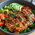 Close-up view of a low carb chicken bowl featuring cauliflower rice, fresh vegetables, and sauce.