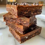 Close-up view of a No Bake Chocolate Protein Bar with a rich chocolate exterior and visible chocolate chips.