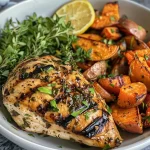 Close-up of a grilled herb chicken bowl with sweet potato fries.