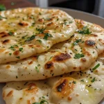 Close-up view of a golden-brown yogurt flatbread with a fluffy texture.
