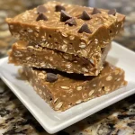 Side view of No Bake Peanut Butter Oatmeal Bars stacked with a slice cut out.
