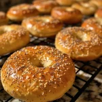Close-up view of a freshly baked homemade bagel with a golden-brown crust and everything bagel seasoning.