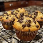 Close-up side view of Greek yogurt chocolate chip muffins with visible chocolate chips.