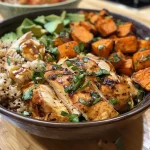 A vibrant bowl filled with diced chicken, roasted sweet potatoes, and fresh greens.