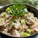 A close-up view of a colorful Herbed Tuna Salad with fresh vegetables and herbs.