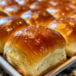 Close-up of freshly baked dinner rolls on a wooden surface.