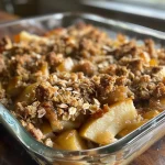 Close-up view of a slice of almond butter apple crisp with a golden-brown topping.