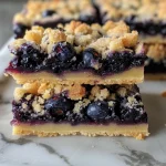 Close-up of juicy blueberry crumble shortbread bars with a golden top layer.
