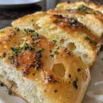 Close-up view of swirled garlic herb bread showing a golden-brown crust and rich texture.