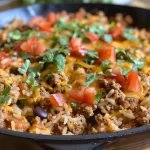 Close-up view of a Ground Beef Burrito Skillet filled with ingredients.