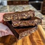 Close-up of healthy no-bake protein chocolate bars arranged on a wooden surface.
