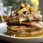 Close-up view of healthy oatmeal apple pancakes stacked on a plate.