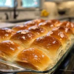 Close-up view of freshly baked homemade dinner rolls on a wooden surface.