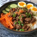A close-up view of a Korean Beef Bowl meal prep, featuring colorful ingredients in meal prep containers.