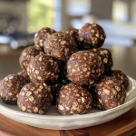 Close-up view of No Bake Fudge Balls, showing rich chocolate texture and rolled in nuts.