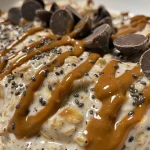 Close-up view of a creamy Peanut Butter Cup Overnight Oats in a glass container.