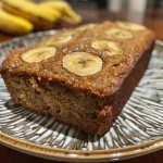 Close-up of a slice of golden brown protein banana bread with a moist texture.