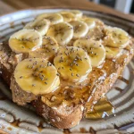 Close-up view of almond butter banana honey toast topped with chia seeds on whole-grain bread.
