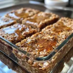 Close-up of baked oatmeal squares with cinnamon swirl and golden brown edges.