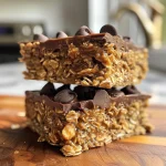 Close-up side view of Protein Chocolate Oat Squares stacked on a white plate.