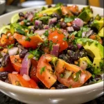 ['Close-up of a vibrant avocado black bean salad with diced avocados and chopped tomatoes.', 'Side view of a colorful black bean salad featuring fresh avocados and onions.', 'A detailed look at a bowl of avocado black bean salad garnished with cilantro.', 'Juicy avocado black bean salad with lime dressing seen up close.']