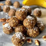 ['Close-up of Banana Bread Energy Bites on a wooden surface.', 'Side view of delicious Banana Bread Energy Bites rolled in coconut.', 'Juicy Banana Bread Energy Bites arranged neatly on a plate.', 'A vibrant display of Banana Bread Energy Bites surrounded by ingredients.']