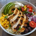 ['A close-up side view of a Chicken Burrito Bowl with vibrant ingredients.', 'Juicy Chicken Burrito Bowl featuring rice, beans, corn, and fresh toppings.', 'A colorful Chicken Burrito Bowl styled with lime, avocado, and cheese.', 'A detailed shot of a Chicken Burrito Bowl displaying layers of chicken and vegetables.']