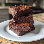 ['Close-up of a decadent double chocolate brownie topped with chocolate chips.', 'Side view of gooey double chocolate cottage cheese brownies on a white plate.', 'Rich chocolate brownie with a moist texture, showcasing melted chocolate on top.', 'Delicious chocolate brownie with a sprinkle of dark chocolate chips, presented on a wooden table.']