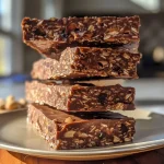 ['Close-up of a chewy chocolate nut protein bar with visible chunks of nuts and chocolate chips.', 'Side view of a high-protein chocolate nut bar showcasing its chewy texture and rich chocolate color.', 'Detailed image of a protein bar with oats, nuts, and dark chocolate, highlighted against a neutral background.', 'A hand holding a chocolate nut protein bar, focusing on its texture and ingredient inclusions.']