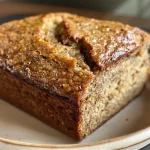 ['Close-up of a freshly baked honey wheat banana bread loaf with a golden crust.', 'Side view of a moist honey wheat banana bread, showcasing its texture and color.', 'Juicy banana bread made with whole wheat flour, displayed on a rustic wooden table.', 'Detailed image of a slice of honey wheat banana bread, highlighting its soft texture and honey glaze.']
