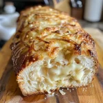 ['Close-up of Onion Cheese Yeast Bread, showcasing its golden crust and melted cheese.', 'Side view of a loaf of Onion Cheese Yeast Bread with visible caramelized onions and cheese.', 'Juicy Onion Cheese Yeast Bread cut to reveal its fluffy texture and rich filling.', 'Freshly baked Onion Cheese Yeast Bread with a crispy crust and gooey cheese oozing out.']