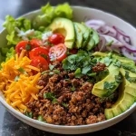 ['Close-up view of a vibrant taco salad bowl filled with fresh ingredients.', 'Side shot of a taco salad bowl featuring ground beef, beans, and colorful toppings.', 'Juicy taco salad bowl brimming with lettuce, cheese, and various toppings.', 'Detailed view of a delicious taco salad bowl showcasing garlicky meat and fresh vegetables.']