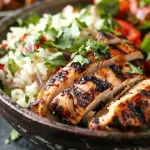 ['Close-up of a Chipotle chicken bowl featuring cubed chicken, black beans, and cilantro lime rice.', 'Side view of a neatly arranged Chipotle chicken bowl with colorful ingredients showcasing freshness.', 'Juicy Chipotle chicken bowl highlighting marinated chicken, black beans, and garnished rice.', 'Detailed view of a flavorful Chipotle chicken bowl with chicken, beans, and cilantro rice.']