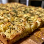 ['Close-up view of Rustic Rosemary Potato Bread with a golden crust and sprinkles of sea salt.', 'Side angle of freshly baked Rustic Rosemary Potato Bread, showcasing its soft interior and rosemary leaves.', 'Deliciously textured Rustic Rosemary Potato Bread highlighted by crunchy sea salt atop a warm crust.', 'Rustic Rosemary Potato Bread positioned elegantly to reveal its inviting crust and fluffy center.']